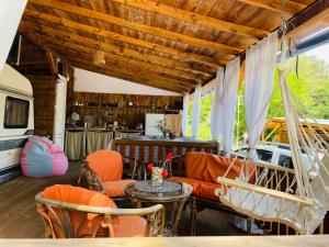 a living room with orange furniture and a hammock at Караваната На Морето in Sozopol