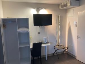 a room with a desk and a table with a chair at Hôtel L'Escale Périgueux Notre Dame in Notre-Dame-de-Sanilhac