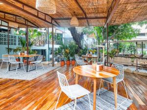 a patio with tables and chairs on a wooden floor at Selina Boquete in Boquete