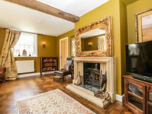 a living room with a fireplace and a mirror at Valley House in Devizes