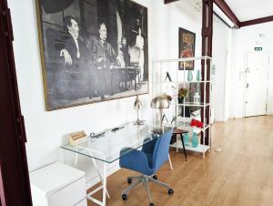 - un bureau en verre et une chaise bleue dans la chambre dans l'établissement Living Plaza de la Paja, à Madrid