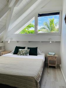 a bedroom with a large bed with a window at Shamrock duplex in Saint Martin