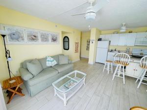 a living room with a couch and a kitchen at #902 Lovers Key Beach Club in Fort Myers Beach