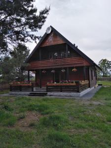 ein kleines Holzgebäude mit Blumenausstellung in der Unterkunft dom drewniany pod lasem in Zatory