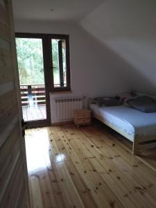 Een bed of bedden in een kamer bij dom drewniany pod lasem