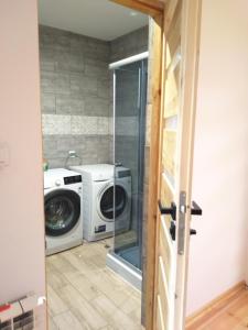 eine Waschküche mit Waschmaschine in der Unterkunft dom drewniany pod lasem in Zatory