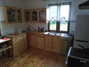 a kitchen with wooden cabinets and a wooden floor at dom drewniany pod lasem in Zatory