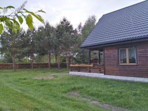 a house with a yard next to a building at dom drewniany pod lasem in Zatory