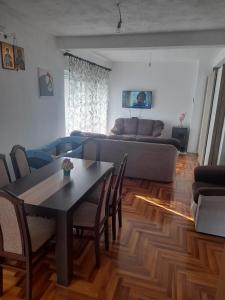 una sala de estar con una mesa y un sofá en Apartman Boki, en Trebinje