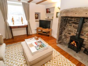 un soggiorno con camino e TV di Cross View Cottage ad Alston