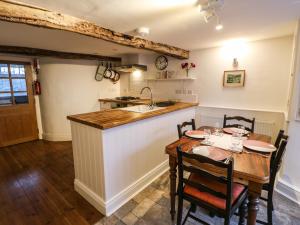 una cucina e una sala da pranzo con tavolo e lavandino di Cross View Cottage ad Alston