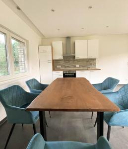 a dining room with a wooden table and blue chairs at Finca Berlin nähe Olympiastadion in Berlin