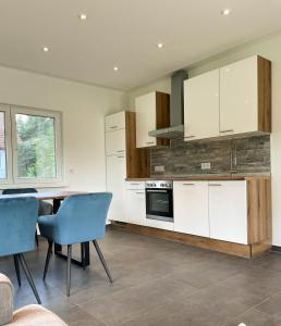 een keuken met witte kasten en een tafel en stoelen bij Finca Berlin nähe Olympiastadion in Berlijn