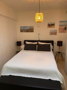 クノック・ヘイストにあるResidence La Zouteのベッドルーム(シャンデリア付きの白い大型ベッド1台付)