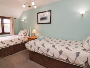 1 dormitorio con 2 camas y ventana en Hedgehog Cottage, en Minehead