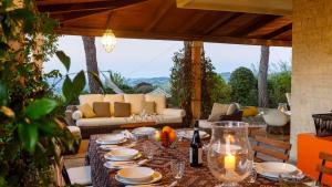 una mesa con platos y velas en el patio en Villa delle Rose - Modern design, pool & AirCO, en Colbordolo