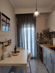 a kitchen with a table with a bottle of wine on it at Eva Beach Apartment in Nea Peramos