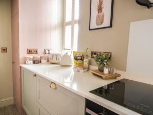 a kitchen with a counter top with a pineapple on the wall at Hideaway Cottage in Penrith