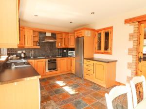 una cucina con armadi in legno e pavimento piastrellato di 4 Killimer Road a Kilrush