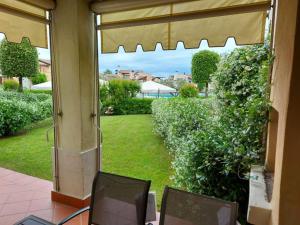 a view of a yard from a patio with two chairs at Garda Resort Village I Borghi in Peschiera del Garda