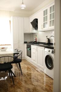 a kitchen with white cabinets and a table and a stove at Misho Apart in Trabzon