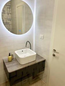a bathroom with a white sink and a mirror at Apartmani CUBE L in Medulin