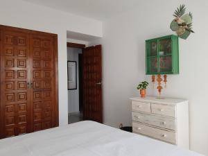 a bedroom with a bed and a dresser and a door at La Trufa - modern, spacious home in Moraira with panoramic sea views in Moraira