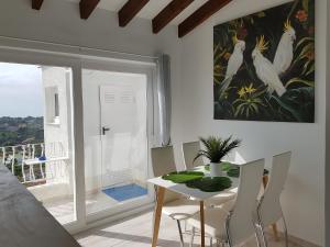 a dining room with a table and chairs and a window at La Trufa - modern, spacious home in Moraira with panoramic sea views in Moraira