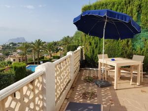 a table with an umbrella on a balcony at La Trufa - modern, spacious home in Moraira with panoramic sea views in Moraira