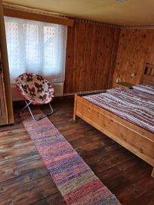 a bedroom with a bed and a chair in it at Cazare La Oana in Haţeg