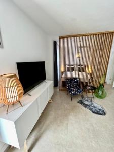 a living room with a flat screen tv on a white cabinet at Apartmani CUBE L in Medulin
