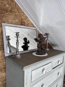 un espejo en la parte superior de un tocador bajo una escalera en La Table d'Elodie, en Le Béage