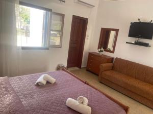 a bedroom with a bed and a couch at Aegean Endless Summer Villa Pefkos in Pefki