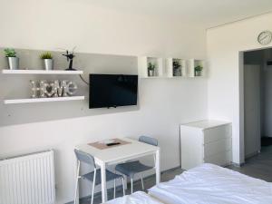 1 dormitorio con mesa, cama y TV en Sea Power Horyzont Apartament 9, en Jastrzębia Góra