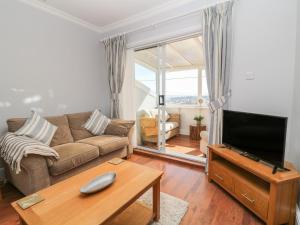 a living room with a couch and a tv at Pebble Lodge in Paignton