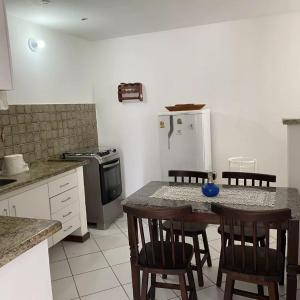 a kitchen with a table and chairs and a refrigerator at Villa Domenico in Salvador