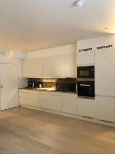 a kitchen with white cabinets and a stove top oven at City Center Oslo- Venice Apartment Sea Side Three-Bedrooms and Two Toilettes in Oslo