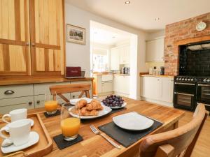 - une cuisine avec une table en bois et de la nourriture dans l'établissement 5 Pond View Cottages, à Brough