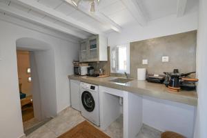 cocina con fregadero y lavadora en kleris apartments 8, en Tinos