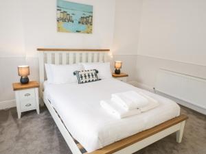 a bedroom with a white bed with two night stands at Bodnant in Llandudno