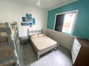 ein kleines Schlafzimmer mit einem Bett und einem Fenster in der Unterkunft Apartamento no Guarujá, a poucos minutos da praia in Guarujá