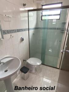 a bathroom with a shower and a toilet and a sink at Apartamento no Guarujá, a poucos minutos da praia in Guarujá