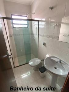ein Bad mit einer Dusche, einem WC und einem Waschbecken in der Unterkunft Apartamento no Guarujá, a poucos minutos da praia in Guarujá