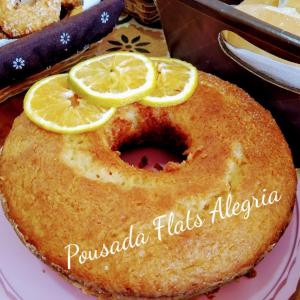 a cake with lemons on top of it on a plate at Pousada Flats Alegria in Olímpia