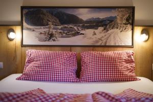 ニーダートハイにあるSonnenhofの赤と白の枕と絵付きのベッド