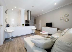 un salon avec un canapé blanc et une cuisine dans l'établissement La Rua de San Pedro by Clabao, à Lugo 10 autres photos