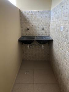 een badkamer met een zwarte wastafel in een bakstenen muur bij Residencial e Chalés Cristal in Palmeiras
