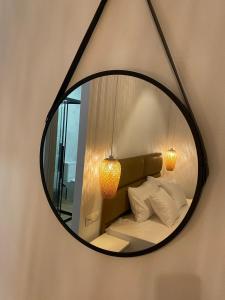 a mirror hanging on a wall with a bed and pillows at DEL REY in Paralia Katerinis