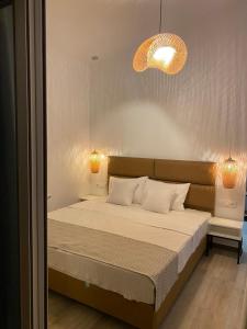 a bedroom with a large bed with two lamps at DEL REY in Paralia Katerinis