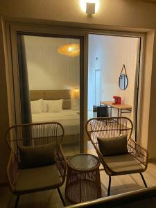 a room with two chairs and a room with a bed at DEL REY in Paralia Katerinis